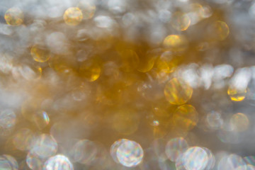 Abstract iridescent and golden bokeh background, glowing yellow circles
