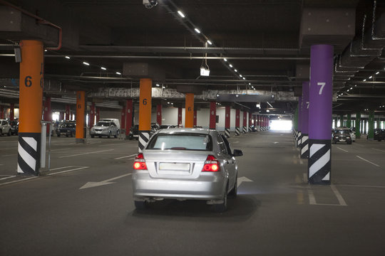 Underground parking is a large shopping center. There are not many cars. The image can be used as a background, there is room for text placement