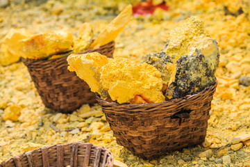 Baskets full of sulfur ore at Mount Ijen crater lake, Indonesia