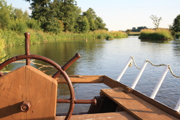 View of the river from behind the helm of the boat