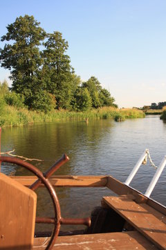 View of the river from behind the helm of the boat