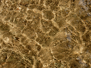 Sunlight being refracted by the rippling water surface. 