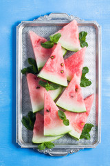 Watermelon slices mint leaves on vintage silver tray