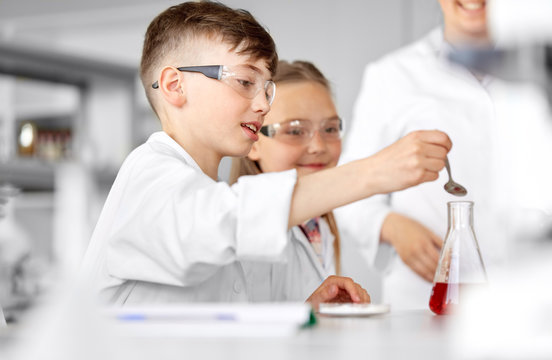 Education, Science, Chemistry And Children Concept - Kids Or Students With Test Tube Making Experiment At School Laboratory