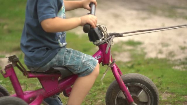 children are riding a tricycle