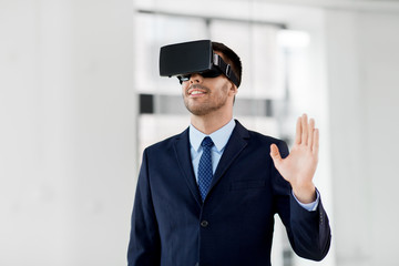 business, technology and augmented reality concept - businessman with vr headset at office