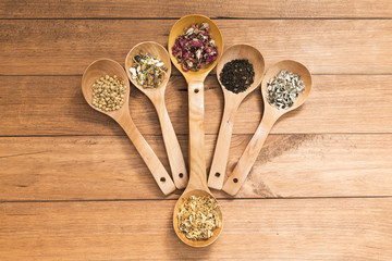 Wooden spoons with different herbs for infusion.