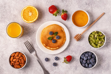 Pancakes with fruit, honey, nuts.