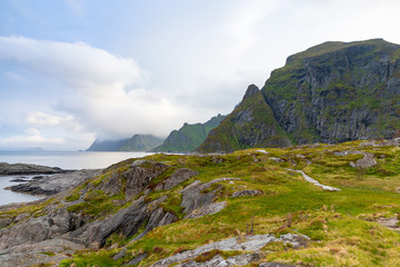 Dramatic sunset clouds moving over steep mountain peaks, Lofoten islands in Norway