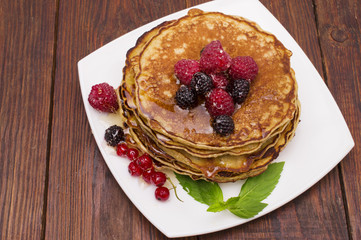 Delicious pancakes with berries and maple syrup. Top