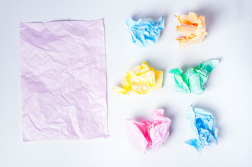 Crumpled colored paper on a white background, smooth pink sheet