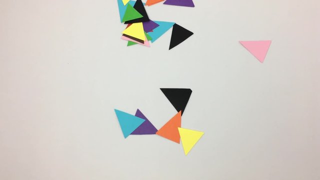 Numero ocho hecho de triangulos de colores se deshace por el viento.