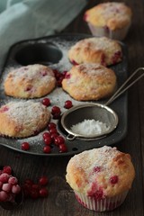 Muffins with red currant sprinkled with powdered sugar. 
