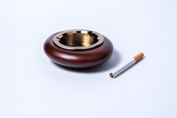 Stylish exquisite ashtray and cigarette on a white background