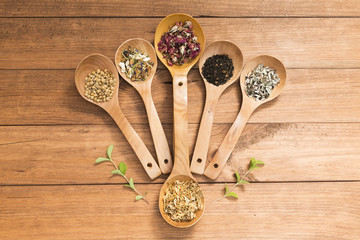 Wooden spoons with different herbs for infusion.