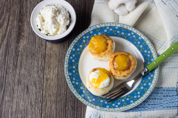 Cottage cheese pancakes on a plate with sour cream and orange jam. Syrniki. Traditional Ukrainian and Russian cuisine