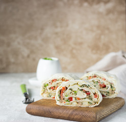 Tuna salad roll sandwich on wooden cutting board. Roll sandwich with tuna, avocado, apples and red...