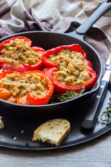 Baked sweet bell peppers stuffed with tuna and bread served in a frying pan.