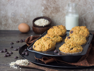 Muffins with chocolate chips (drops) in bakeware (muffin pan) on linen towel. Basic muffin recipe. Homemade muffins for breakfast or dessert.