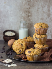 Muffins with chocolate chips (drops) in bakeware (muffin pan) on linen towel. Basic muffin recipe. Homemade muffins for breakfast or dessert.