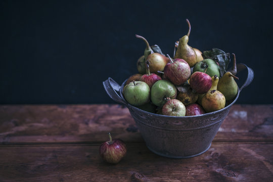 Organic apples and pears in a rustic bucket