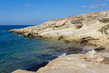 It shows the rocky coast of the Mediterranean, beautiful blue waters and blue sky