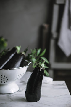 Aubergine or eggplant on a mable kitchen surface