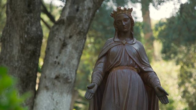 The statue of the Mother of God in a park. 4K