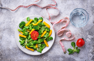 Obraz na płótnie Canvas Healthy vegetable salad, water and measuring tape