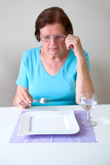 Seniorin mit einem leeren Teller