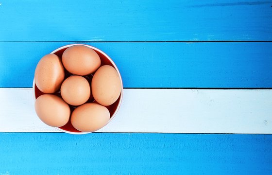 egg in a bowl on blue wood background