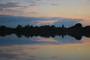 Landscape - stunning dusk at the summer lake with dynamic clouds