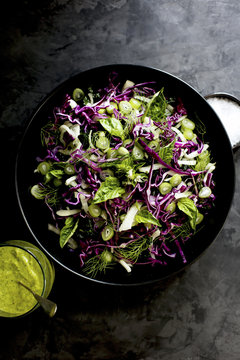 Kale Fennel Salad with Lemon Basil Pesto Vinaigrette photographed on a black background.