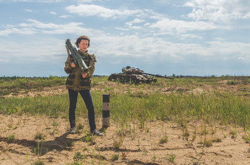 girl in military uniform and jeans with a Bazooka in her hands