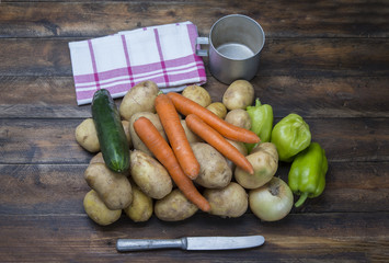 Potatos and vegetable on the rustic table with knife