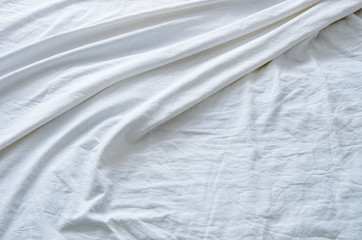Obraz premium Top view of wrinkles on an unmade bed sheet after waking up in the morning.
