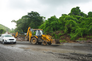 Heavy machinery repair the road in India. Equipment for repair a road. Bulldozer prepare build a road. Wilderness Indian country and building infrastructure.