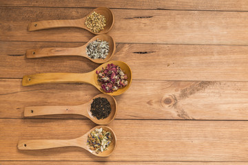 Wooden spoons with different herbs for infusion.