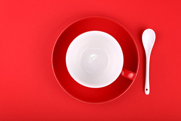Empty white tea coffee cup and saucer on red