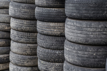 Obraz premium Old used car tires stacked in stacks
