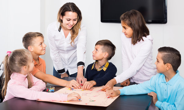 Children making move on pre-marked surface of board game