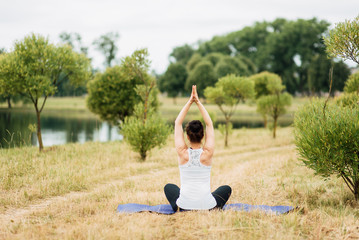 Young girl doing yoga in morning park.Woman Yoga - relax in nature