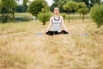 Young girl doing yoga in morning park.Woman Yoga - relax in nature