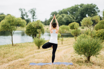 Young girl doing yoga in morning park.Woman Yoga - relax in nature