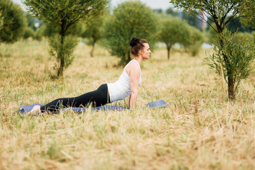 Young girl doing yoga in morning park.Woman Yoga - relax in nature