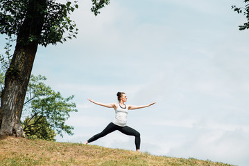 Young girl doing yoga in morning park.Woman Yoga - relax in nature
