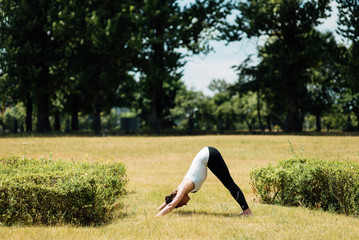 Young girl doing yoga in morning park.Woman Yoga - relax in nature