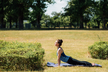 Young girl doing yoga in morning park.Woman Yoga - relax in nature