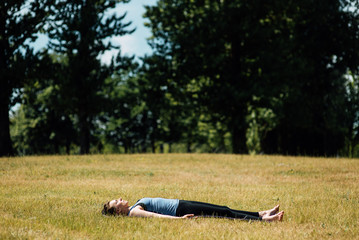 Young girl doing yoga in morning park.Woman Yoga - relax in nature
