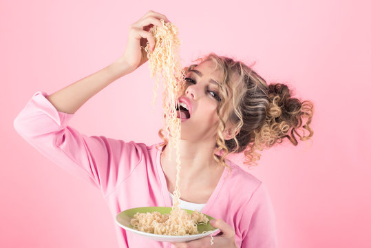 Girl eating noodles by hands. Girl hold plate of spaghetti. Morning breakfast. Attractive woman eating noodle. Adorable woman with curly hair eat pasta. Fashion&beauty. Diet, food, meal. Italian food.